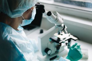 Scientist working in laboratory with microscope